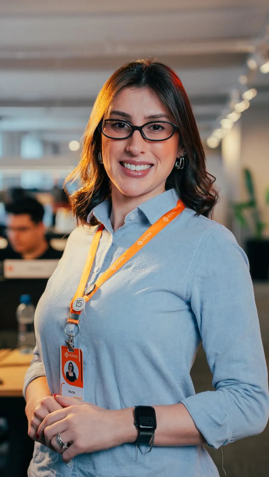 Trainee da Rottas sorrindo no escritório
